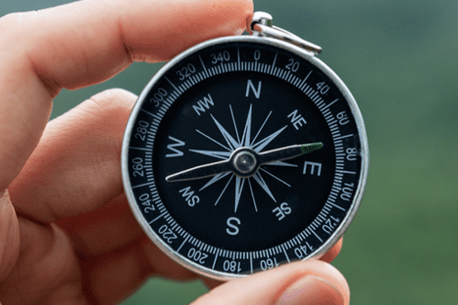 Compass with green blurred background